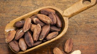 A rustic scoop of roasted pili nuts on a table
