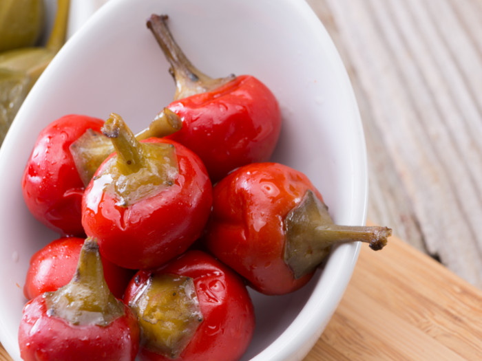 Cooked pimentos in a white bowl on a wooden kitchentop