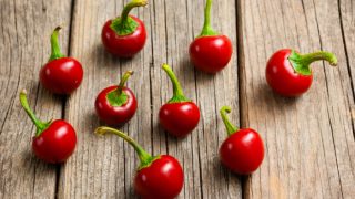 Red pimiento peppers or cherry peppers on a wooden counter