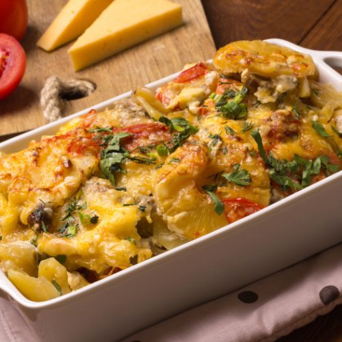 Pineapple casserole with cream, cheese, pineapples, and butter in the baking dish.