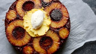 A flat-lay shot of pineapple upside down cake on a white napkin