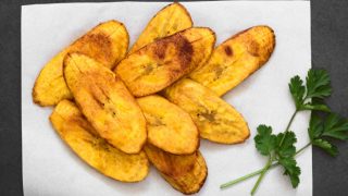 Plantain chips on a parchment paper garnished with cilantro