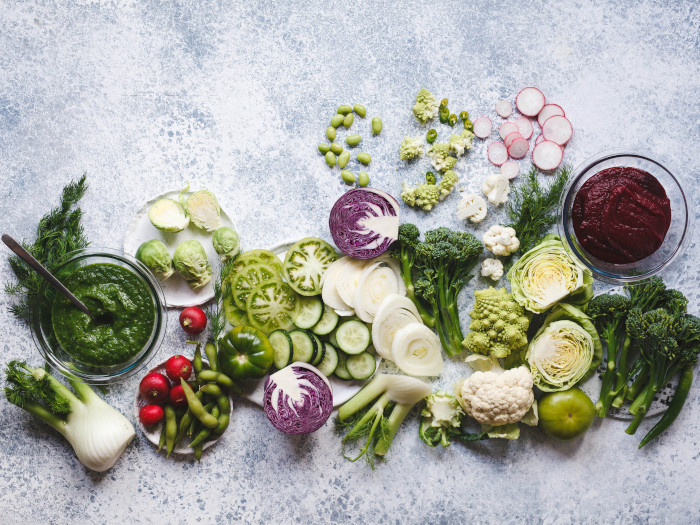 Fresh green vegetables for a plant-based diet on a blue background