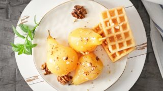 Delicious poached pears in wine and waffles on a plate