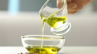Oil being poured into a glass bowl