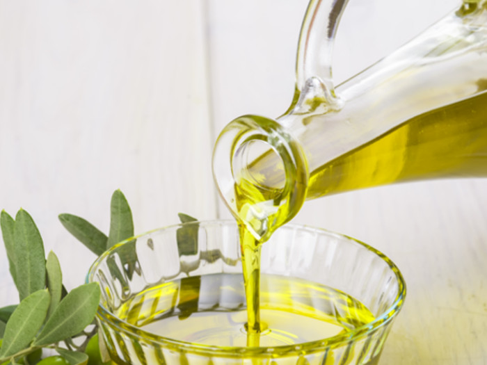 Pouring oil from a bottle in a bowl