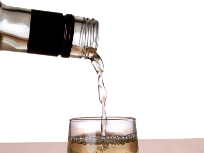 Extreme close-up of liquid being poured from a bottle into a glass.