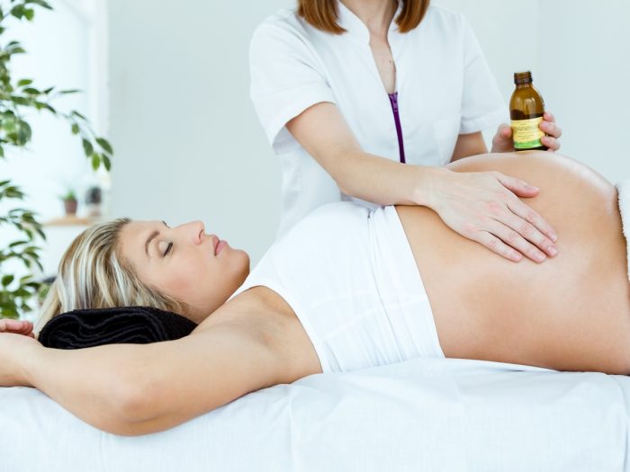Pregnant woman gettin a stomach massage by another woman