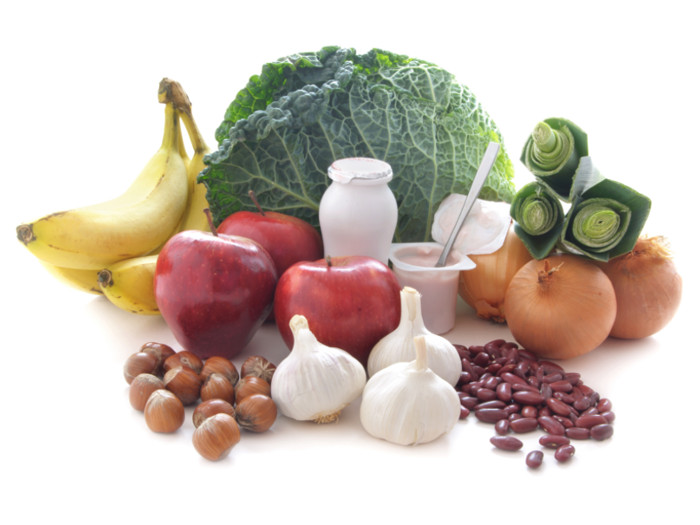 Onions, apples, cabbage and other fruits and vegetables against a white background