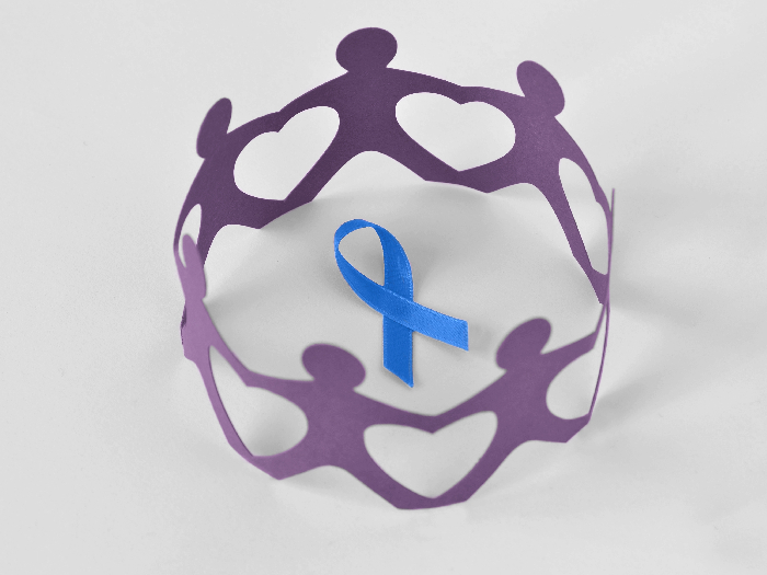 Paper people in a circle around blue ribbon on white background