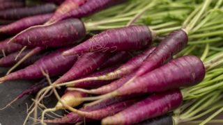 A close-up shot of purple carrots