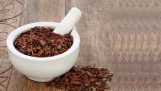 Pygeum bark seeds in a white mortal on a wooden table