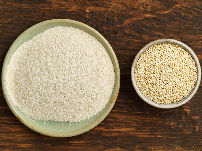 Quinoa and quinoa flour in small bowls on a wooden counter