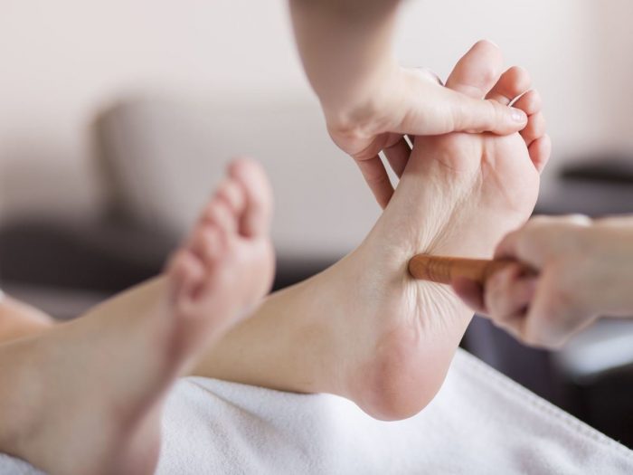 Close-up of foot undergoing reflexology in a spa