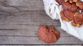 Close up of reishi mushrooms on a white cloth on a wooden table