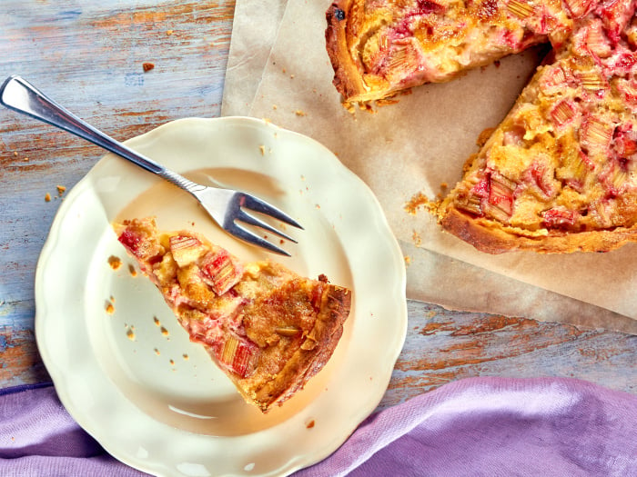 Homemade pie with rhubarb and custard on a wooden table