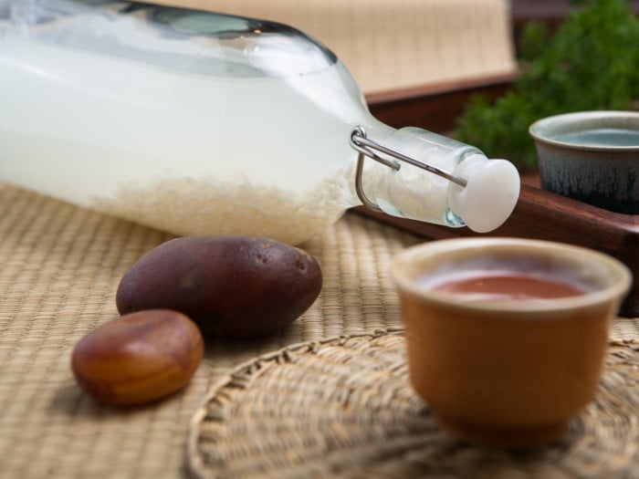 A bottle of rice wine and two pebbles on a table