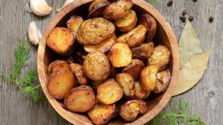 Roasted potato in bowl on wooden table - Image