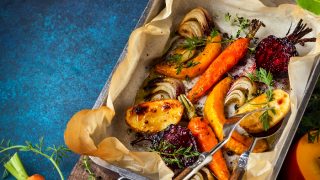Oven roasted vegetables with garlic and herbs on the baking tray.