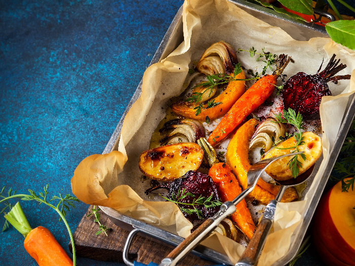 Oven roasted vegetables with garlic and herbs on the baking tray.