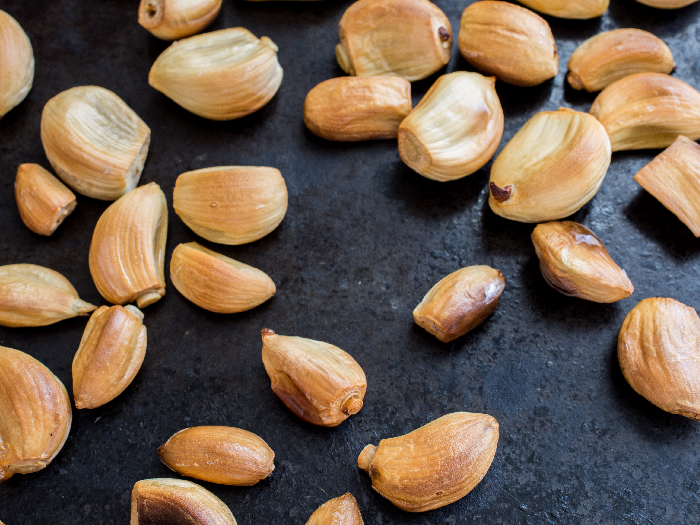 Roasted garlic cloves against a black background