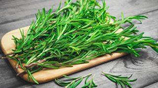 A bunch of rosemary herb in a wooden board