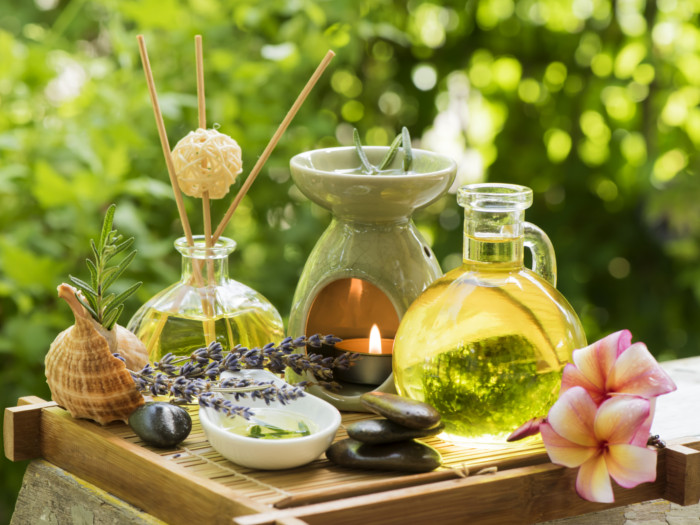 Rosemary oil bottle, aromatherapy set, and lavender on a wooden mat