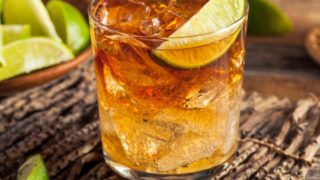 A cocktail with ice cubes and lemon in it