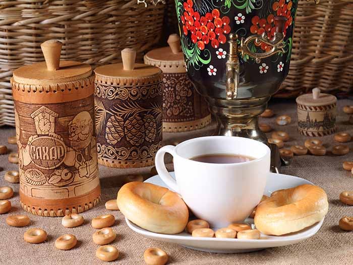 Cup and saucer with tea and bagels with a samovar at the back