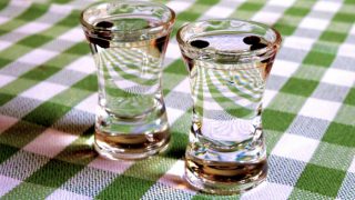 Sambuca in shot glasses on a green and white checkered table