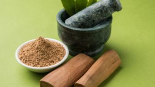 Sandalwood stick and powder on a table with a mortar and pestle