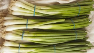 Three bunches of scallions on a table