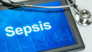 Sepsis written on a blue-screened tab with a stethoscope over it.