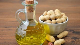 Groundnut oil bottle with groundnuts on the side
