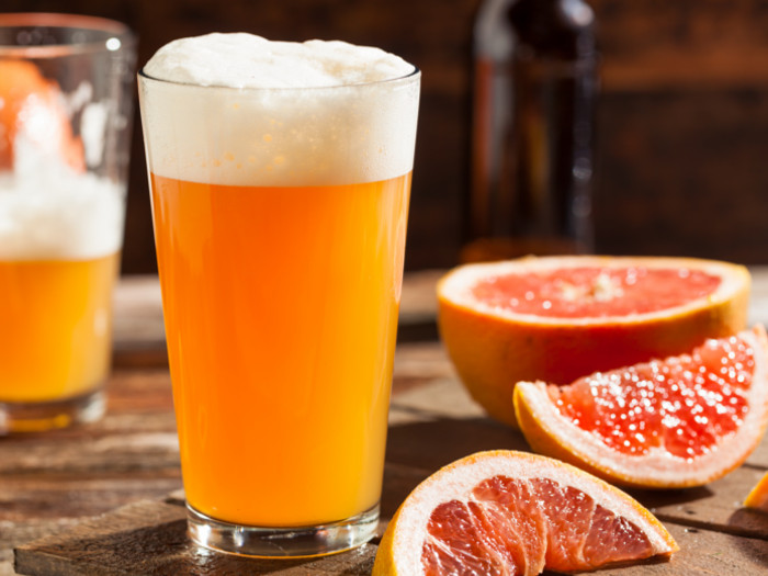 Shandy in a beer glass and grapefruit slices on a counter