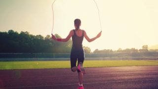 Woman using a skipping rope on an open ground