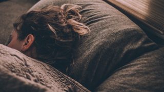 A woman sleeping with her head on a pillow
