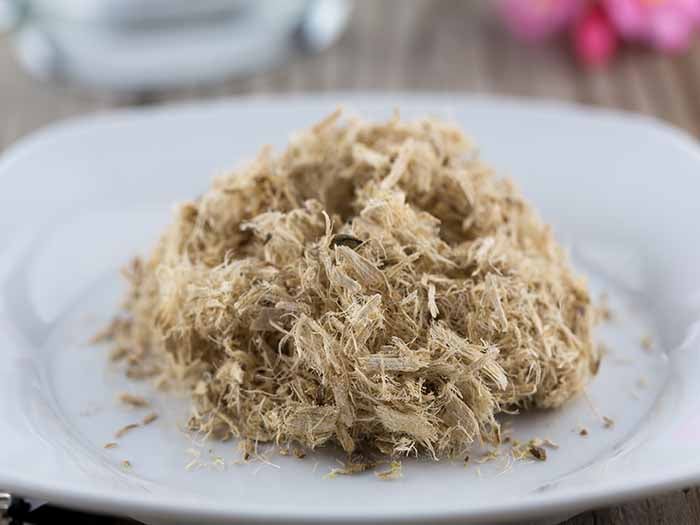 Extreme close-up of dried slippery elm on a white plate.