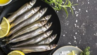 A plate filled with smelts kept atop a black granite platform
