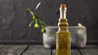 Close up of a bottle of snake oil on a wooden table