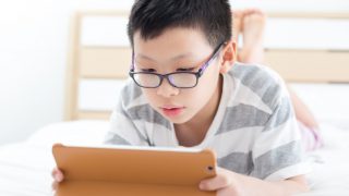 A young boy playing games on his tablet