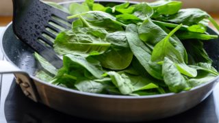Cooking fresh spinach in a pan on the stove