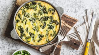 Potato and spinach frittata in a pan on a light background