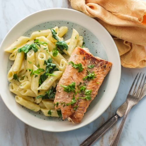 Italian fried salmon and penne pasta with creamy spinach alfredo pasta sauce