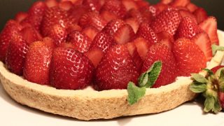 A Cream Pie covered with strawberries