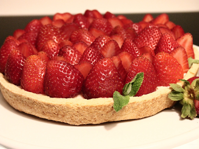 A Cream Pie covered with strawberries