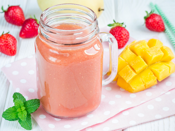 Healthy smoothie with strawberry, mango, and banana in a glass jar