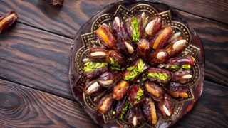 A plate with stuffed dates on a wooden table