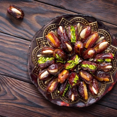 A plate with stuffed dates on a wooden table