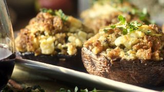 Stuffed mushrooms with Italian sausage, breadcrumbs, fresh sage, thyme, and melted blue cheese; with a glass of red wine